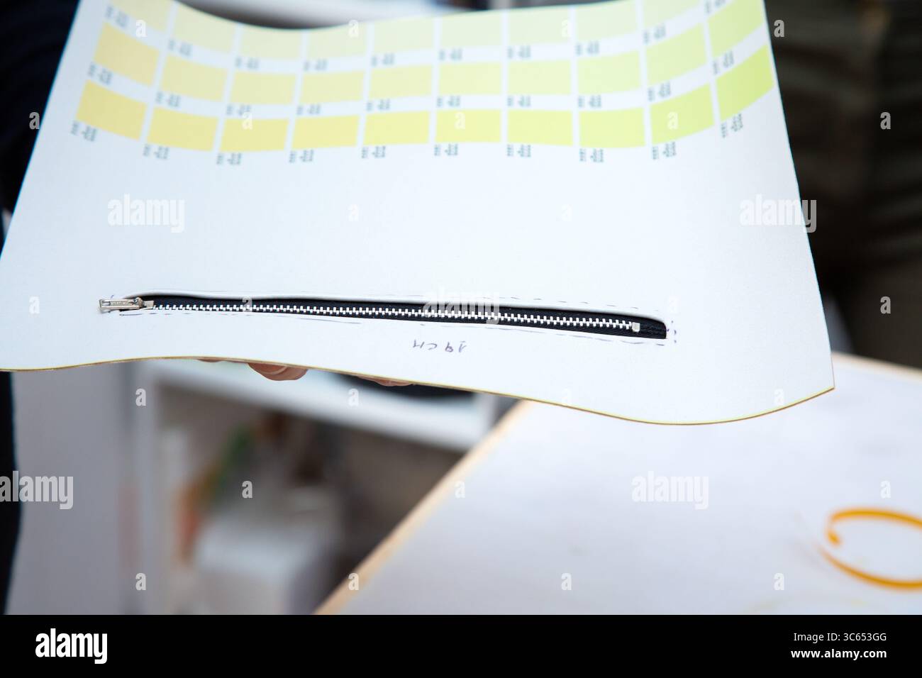 Una persona tiene un foglio con dei quadrati gialli sulla sua superficie Foto Stock