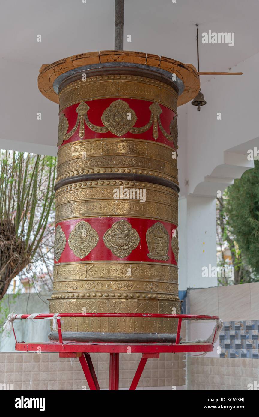 Tradizionale ruota di preghiera buddista fuori da un monastero, simbolo di fede e spiritualità, utilizzata per la meditazione e il canto dei mantra. Foto Stock