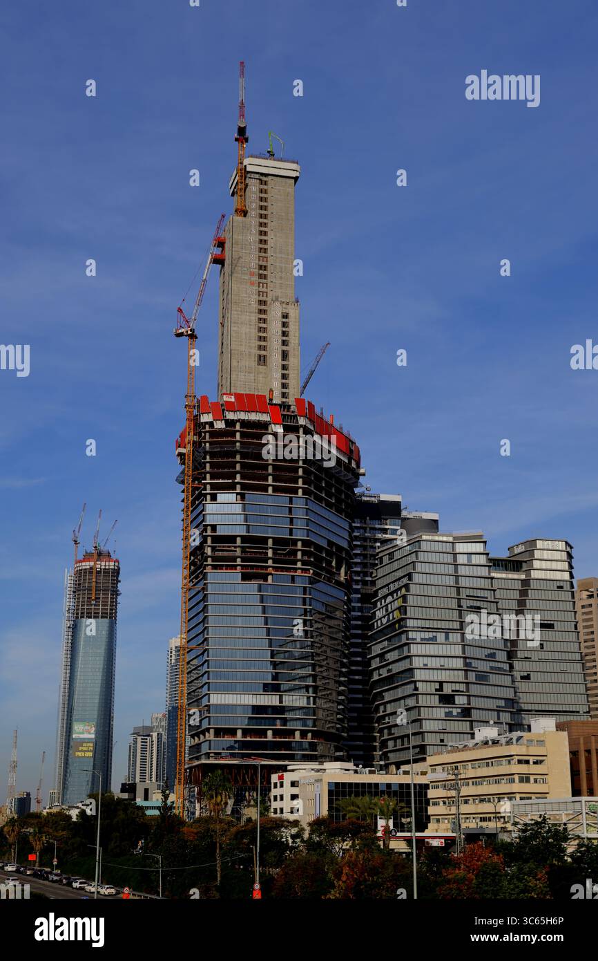 La struttura rialzata ToHa Tower 2 di Tel Aviv-Jaffa espone il nucleo in acciaio e il podio in vetro contro il cielo limpido, catturando lo slancio dinamico della crescita urbana. Foto Stock