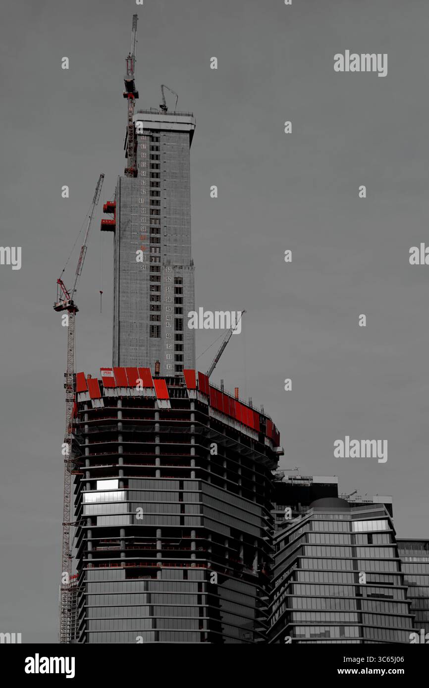 Le crescenti strutture in acciaio e vetro salgono nel cielo come un alto cantiere a Tel Aviv-Jaffa emerge contro un chiaro trambusto urbano dello skyline. Foto Stock