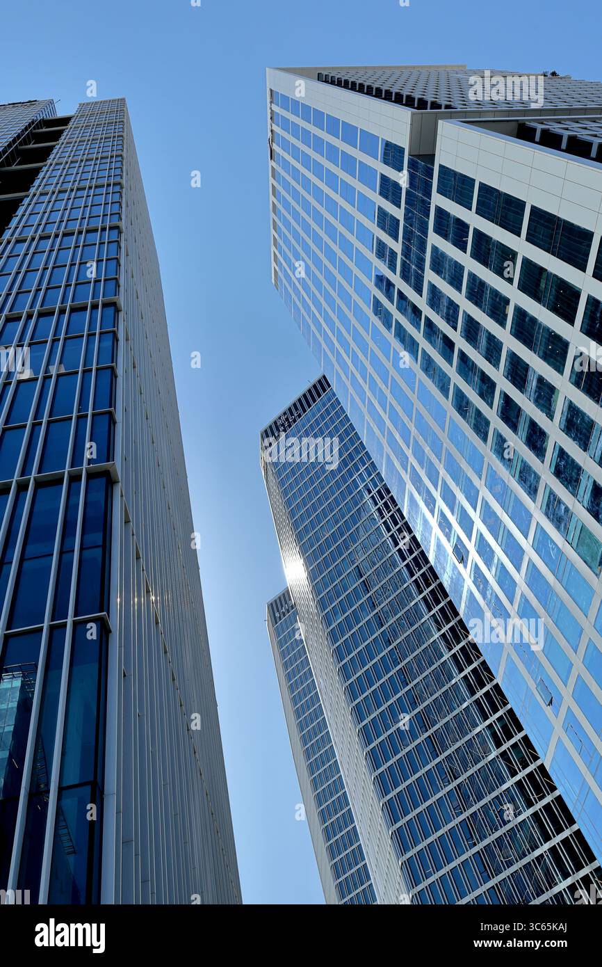 I moderni grattacieli in vetro di Tel Aviv-Jaffa si innalzano in un cielo blu vivace, catturando al meglio la simmetria urbana, la luce e il design architettonico audace. Foto Stock