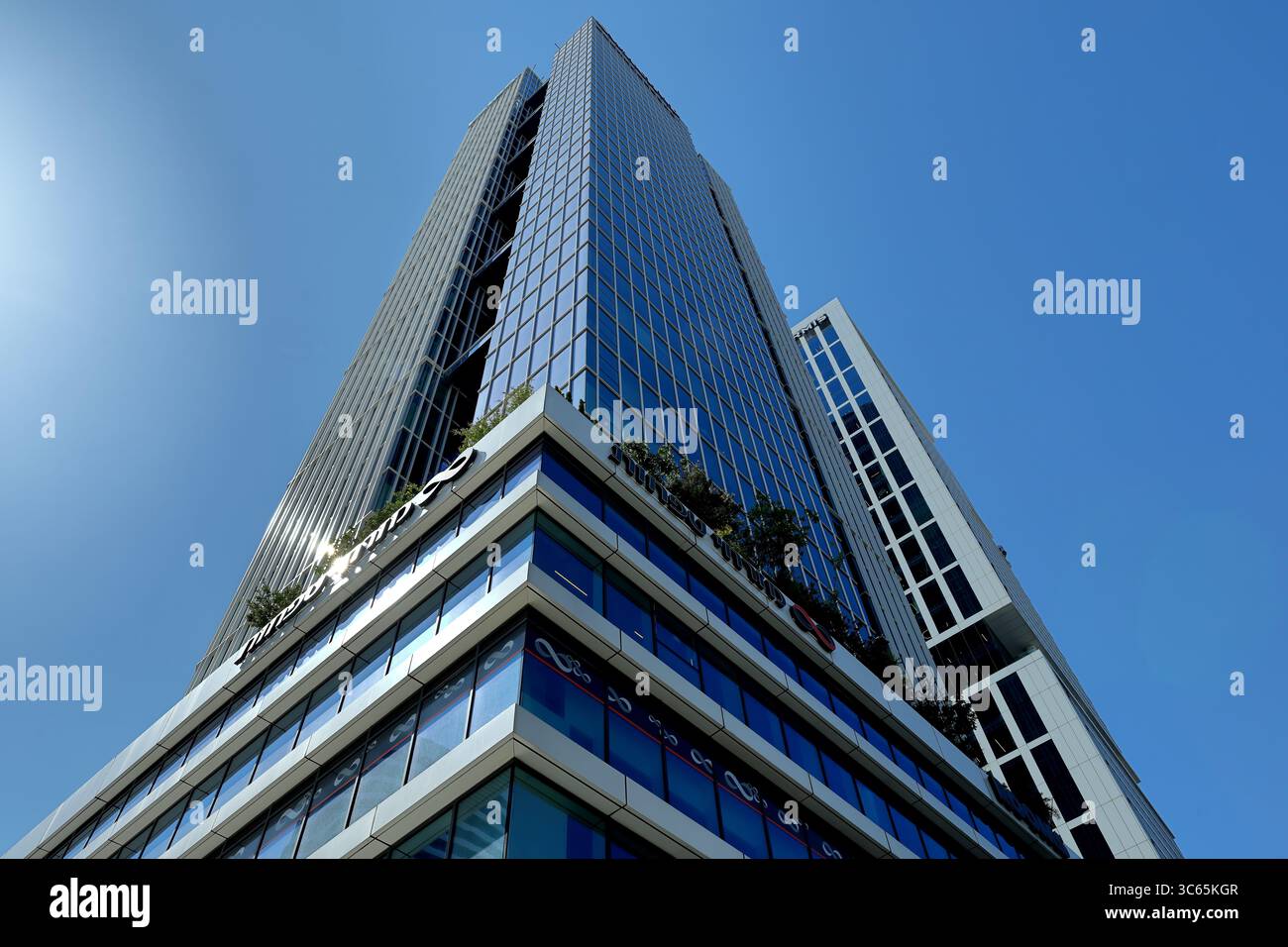 Un moderno grattacielo di vetro a Tel Aviv-Jaffa si erge su un cielo blu limpido, evidenziando linee geometriche eleganti e un design urbano contemporaneo. Foto Stock
