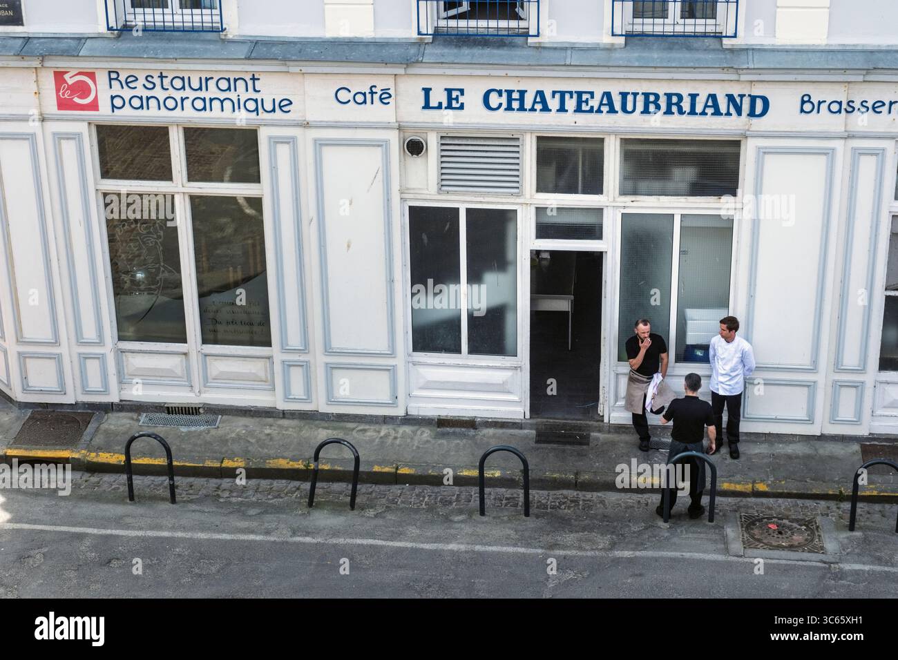 Il personale del ristorante si prende una pausa sul marciapiede, Saint-Malo, Bretagna, Francia Foto Stock