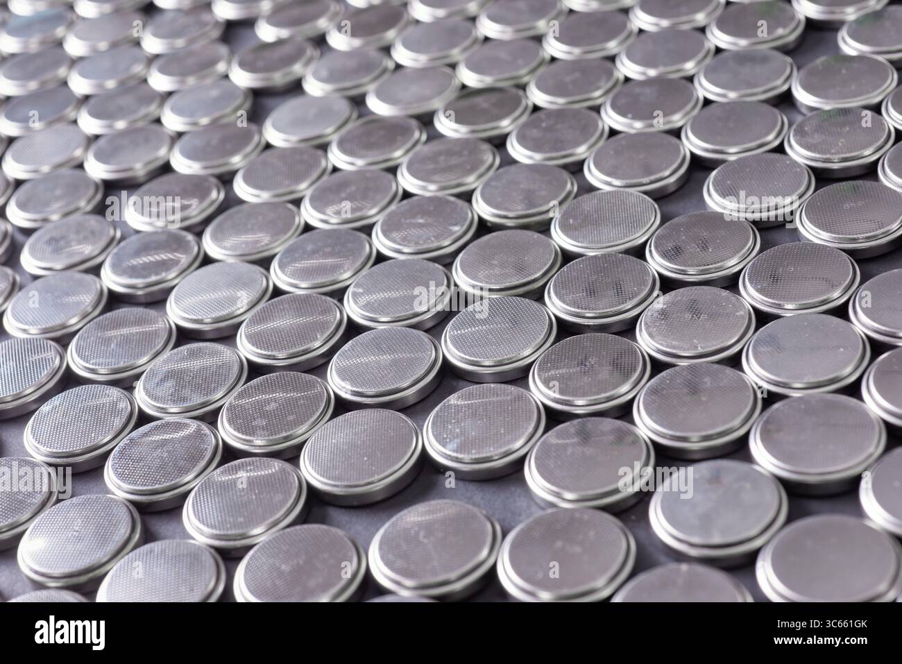 Primo piano di un enorme gruppo di batterie a bottone usa e getta su un tavolo Foto Stock
