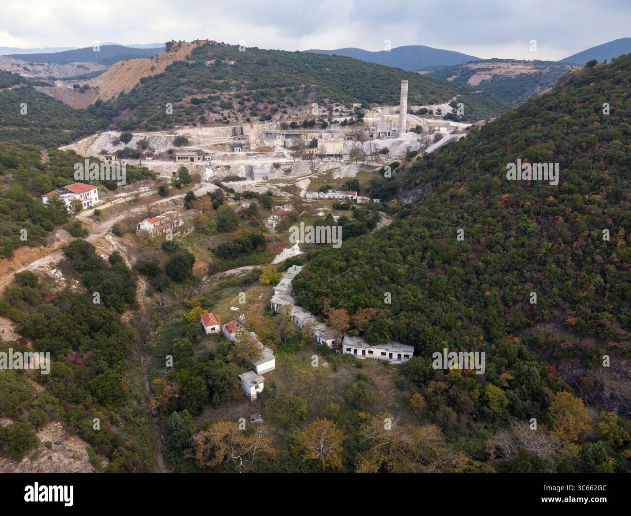 Vista aerea di un netto contrasto tra gli edifici industriali e le lussureggianti colline circostanti, Vavdos, Grecia. Foto Stock