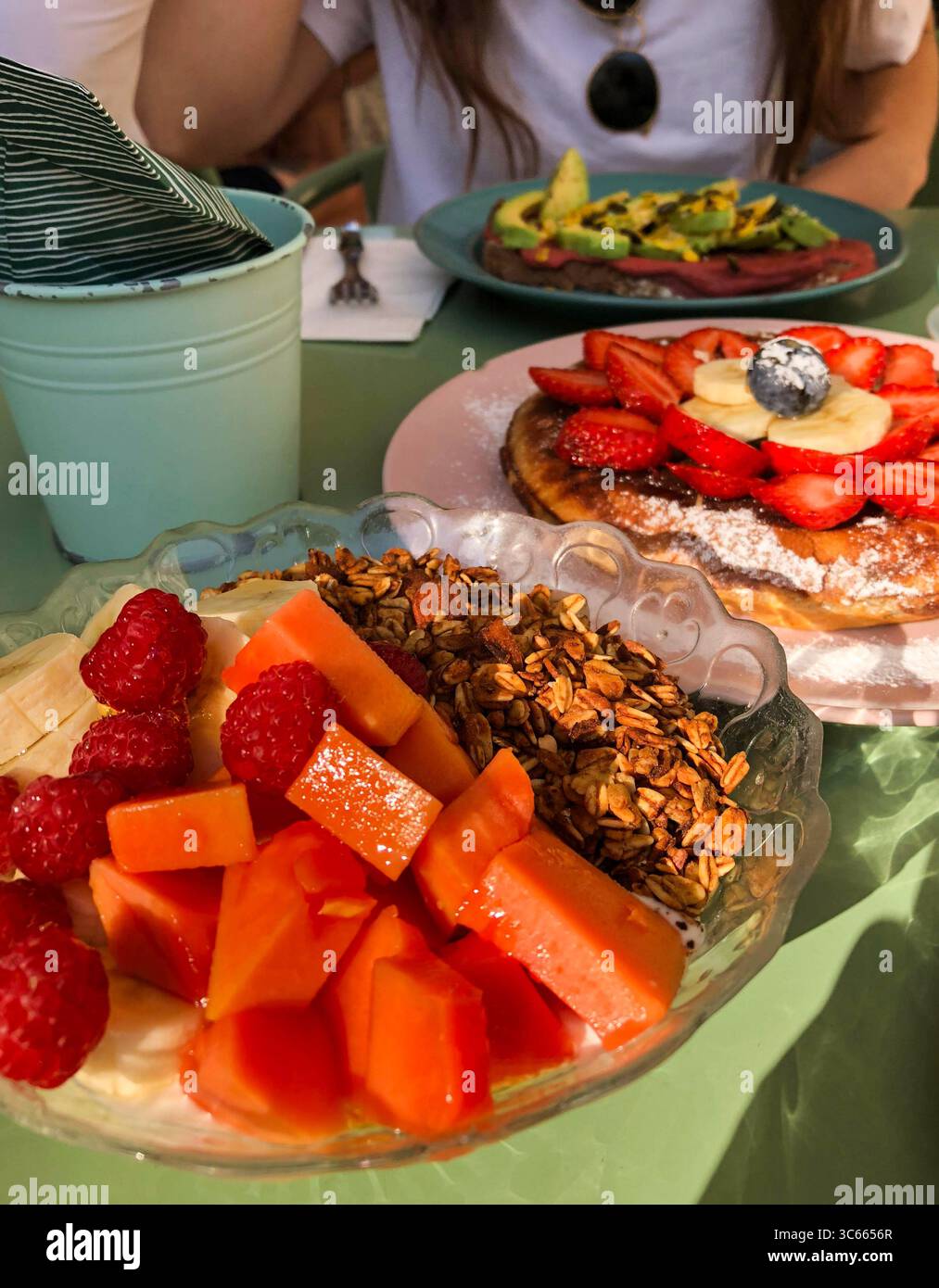 Brunch colorato con frutta fresca, muesli e waffle serviti all'aperto Foto Stock