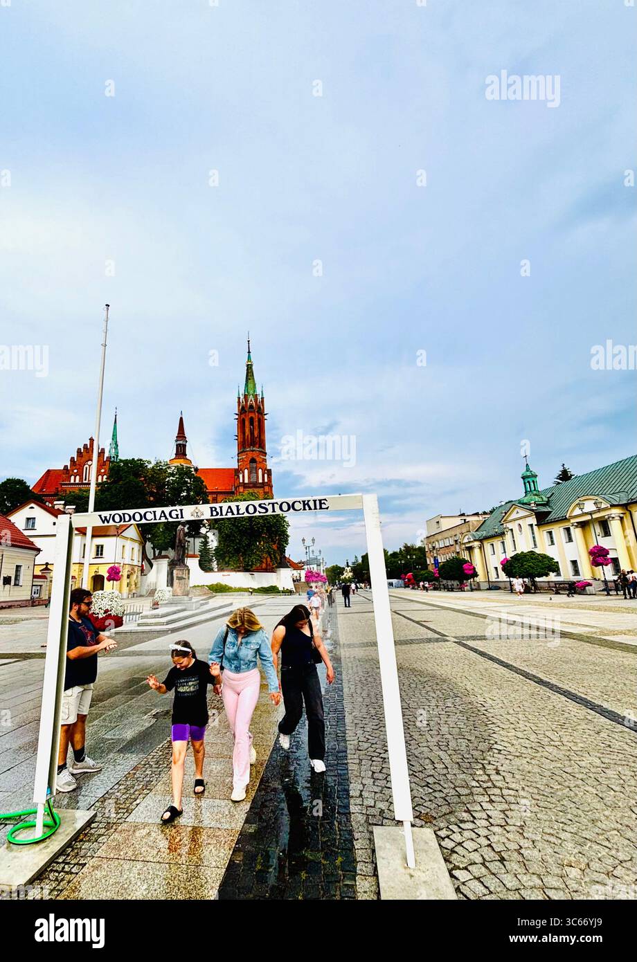 Uno spruzzo d'acqua intrattiene la gente del posto durante i mesi estivi a Bialystok, in Polonia. - Immagine stock catturata con smartphone