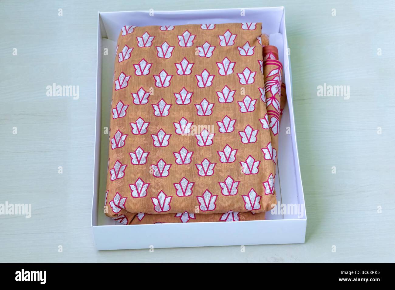 Un sari in cotone stampato con motivi floreali presentato in una confezione regalo. I sari sono una scelta popolare per le donne del Bangladesh, specialmente durante i matrimoni e i festival. Essere Foto Stock