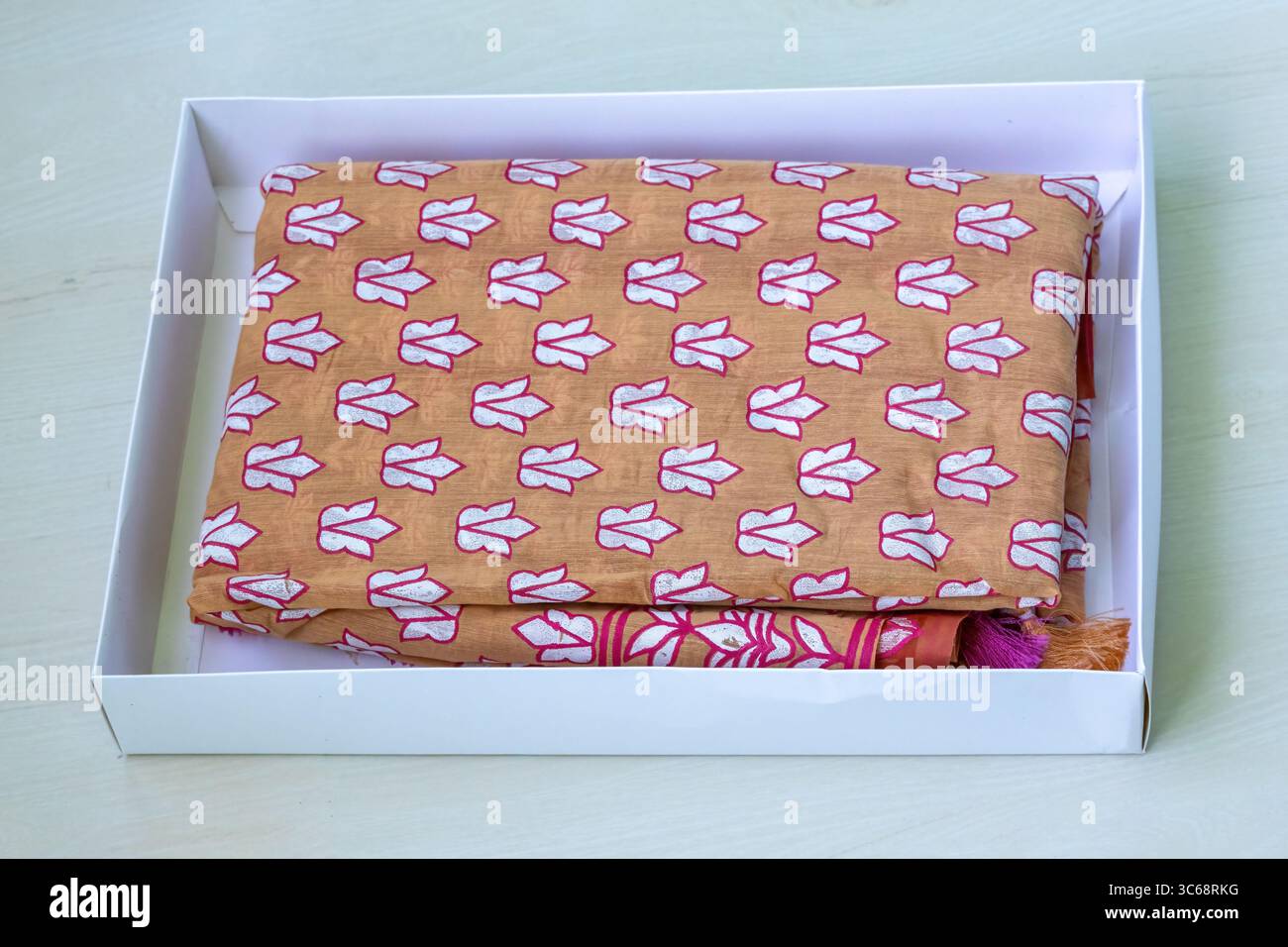 Un sari in cotone stampato con motivi floreali presentato in una confezione regalo. I sari sono una scelta popolare per le donne del Bangladesh, specialmente durante i matrimoni e i festival. Essere Foto Stock