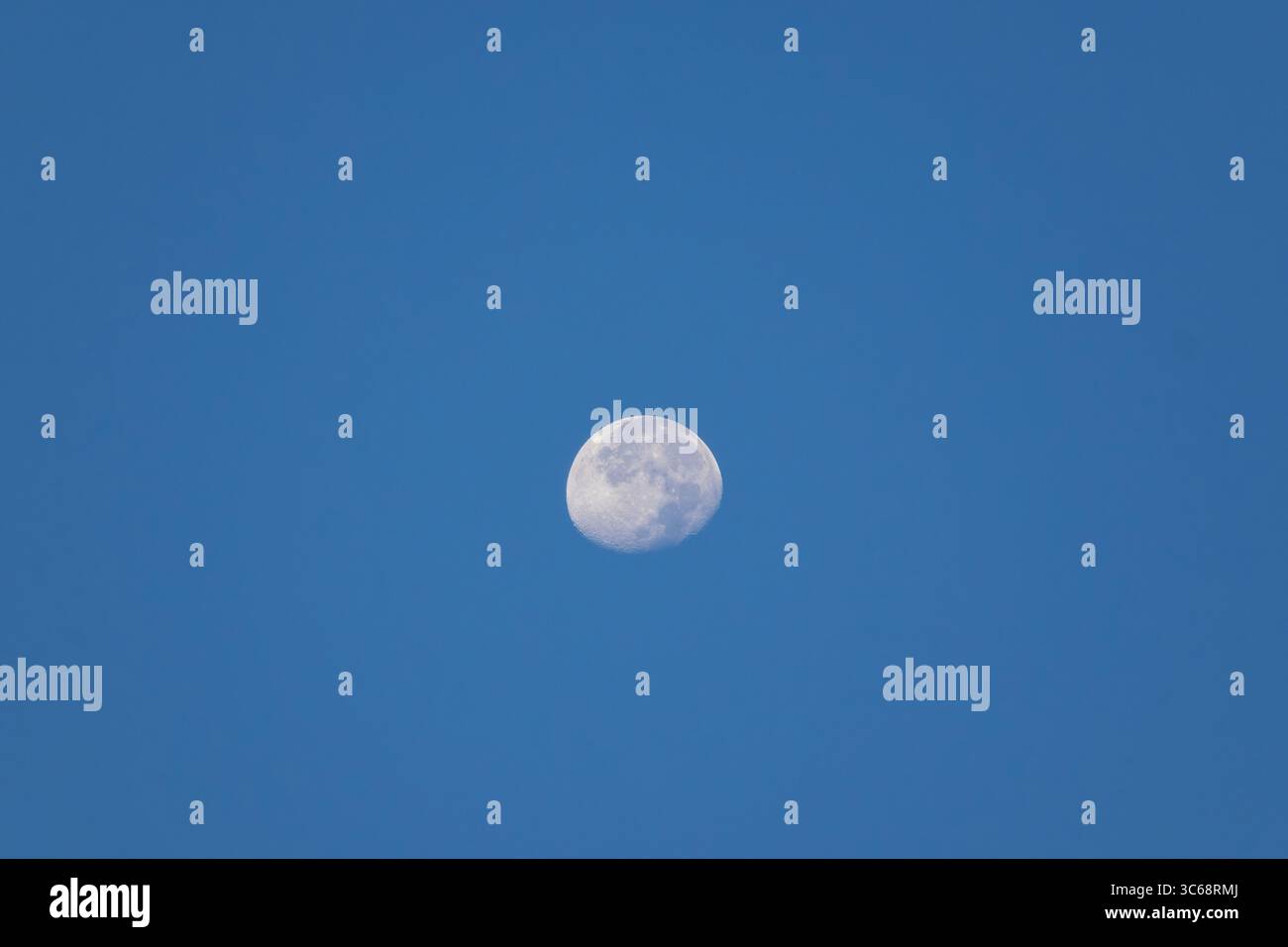 Una bella luna quasi piena brilla in un cielo azzurro e limpido durante il giorno. Foto Stock