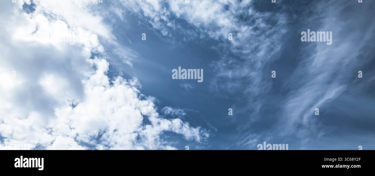 Splendida vista di un cielo blu sereno punteggiato da soffici nuvole bianche, che irradiano tranquillità. L'immagine cattura un'atmosfera tranquilla e può essere utilizzata per Foto Stock