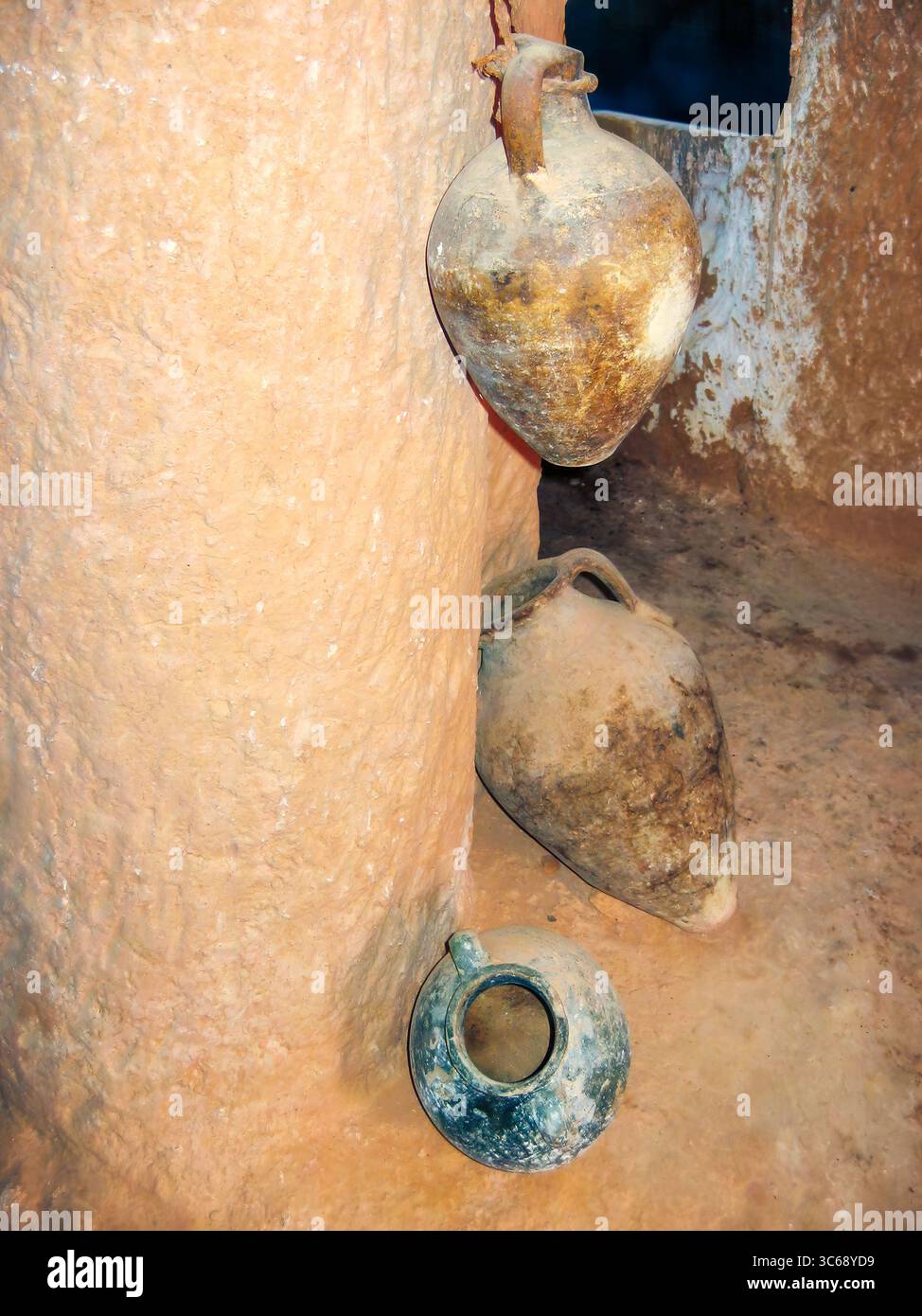 Interni tradizionali berberi con ceramica rustica di argilla appesa su pareti testurizzate, che mostrano il patrimonio culturale e l'artigianato Foto Stock