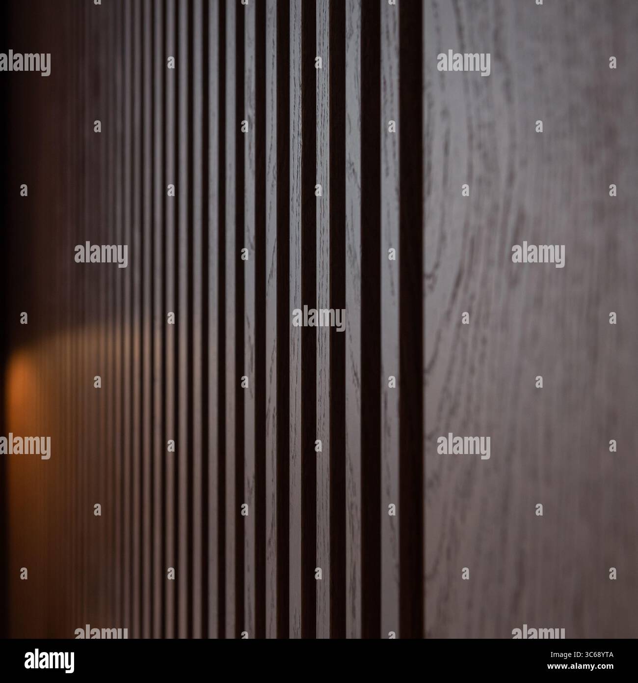 Feritoie in legno marrone all'interno di una stanza scura che crea uno sfondo a righe. Vista ravvicinata della struttura a grana di legno. Foto Stock