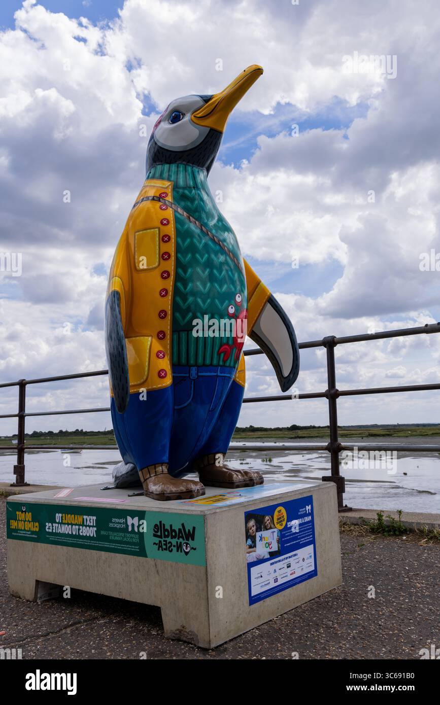 Colorata statua del pinguino in mostra a Leigh-on-Sea, Essex, Regno Unito. Fa parte di un percorso artistico pubblico con design vivaci e sponsorizzazioni della comunità. Foto Stock