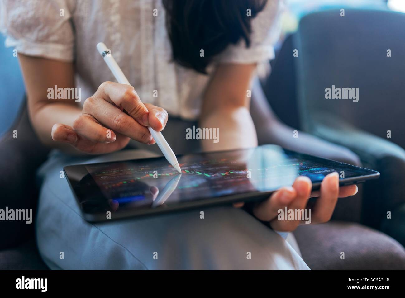 Donna investe azioni online sul trading su app per piattaforma mobile Foto Stock