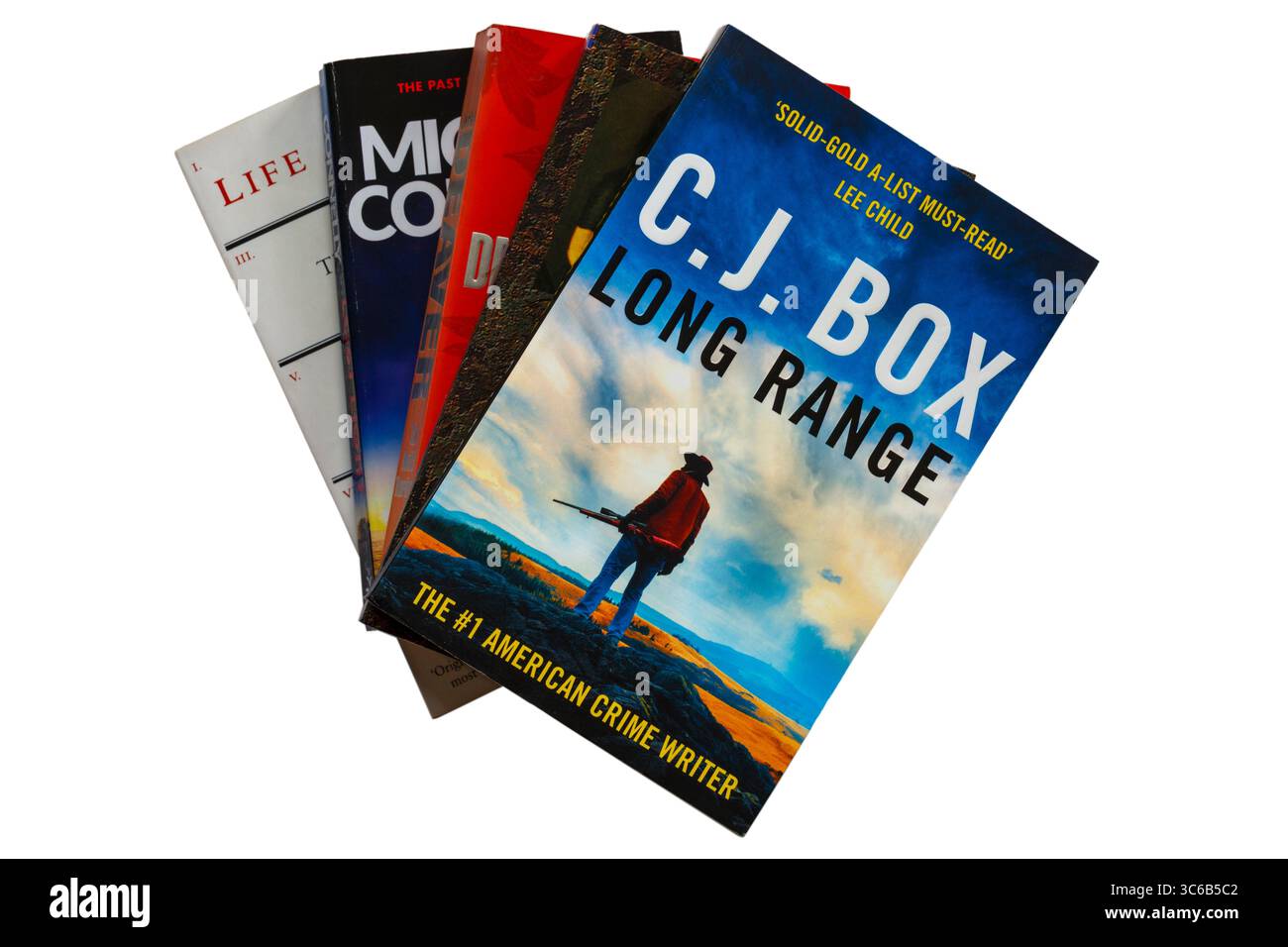 Selezione di libri con libro Long Range di C.J. Box in cima isolato su sfondo bianco - parte del ventesimo libro della serie di Joe Pickett Foto Stock