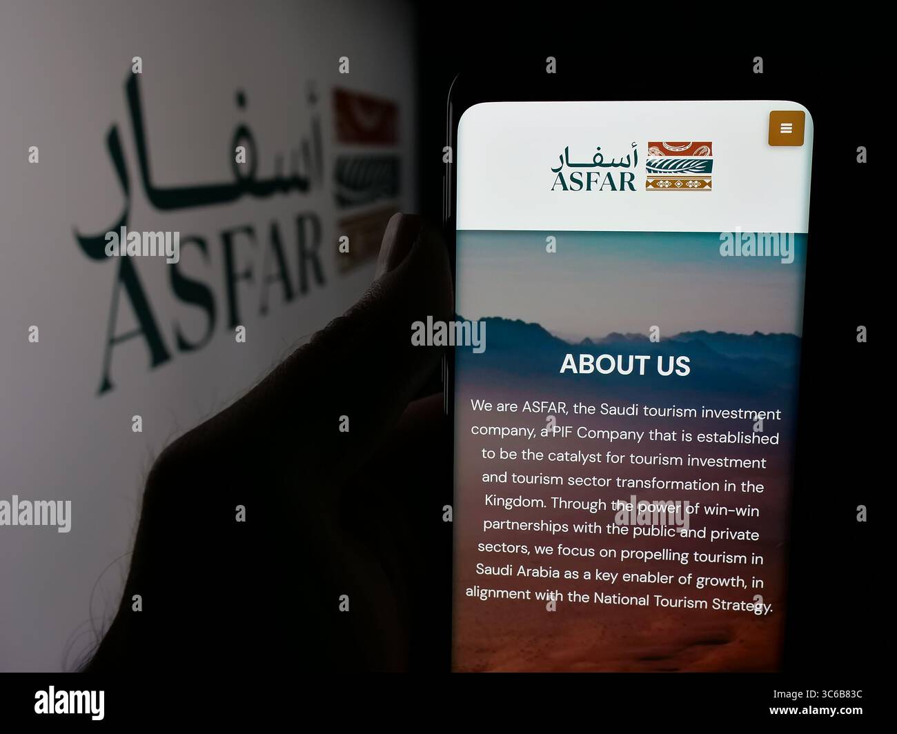 Stoccarda, Germania - 06-14-2025: Persona con smartphone con pagina web della società saudita di investimento nel turismo ASFAR sullo schermo davanti al logo. Foto Stock