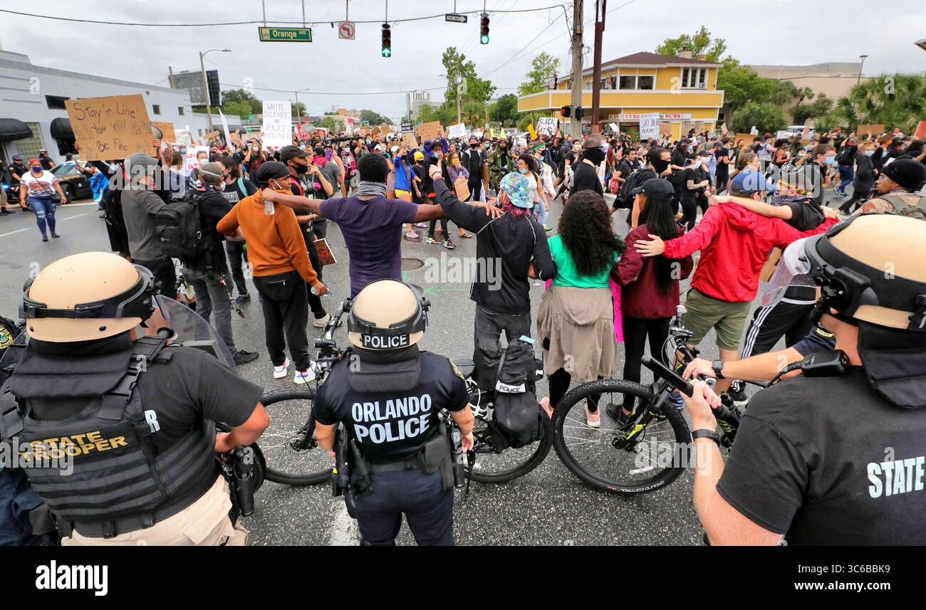 4 giugno 2020, Orlando, Florida, USA: I manifestanti collegano le armi per impedire ai loro compagni di manifestanti di impegnarsi con la polizia mentre marciano attraverso l'incrocio tra Colonial Drive e Orange Avenue, a Orlando, Flag., giovedì 4 giugno 2020. L'intersezione è tra le più trafficate della città. Le proteste di Orlando continuarono giovedì per l'uccisione di George Floyd da parte della polizia a Minneapolis, maggio 25. (Immagine di credito: © TNS via cavo ZUMA) Foto Stock