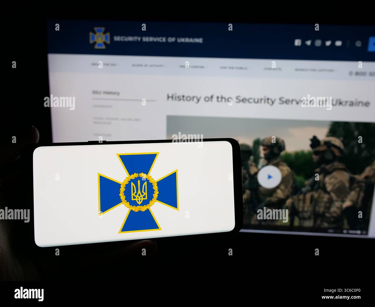 Stoccarda, Germania - 06-18-2025: Persona in possesso di smartphone con logo del servizio di sicurezza Sluzhba Bezpeky Ukrainy SBU sullo schermo di fronte al sito web. Foto Stock
