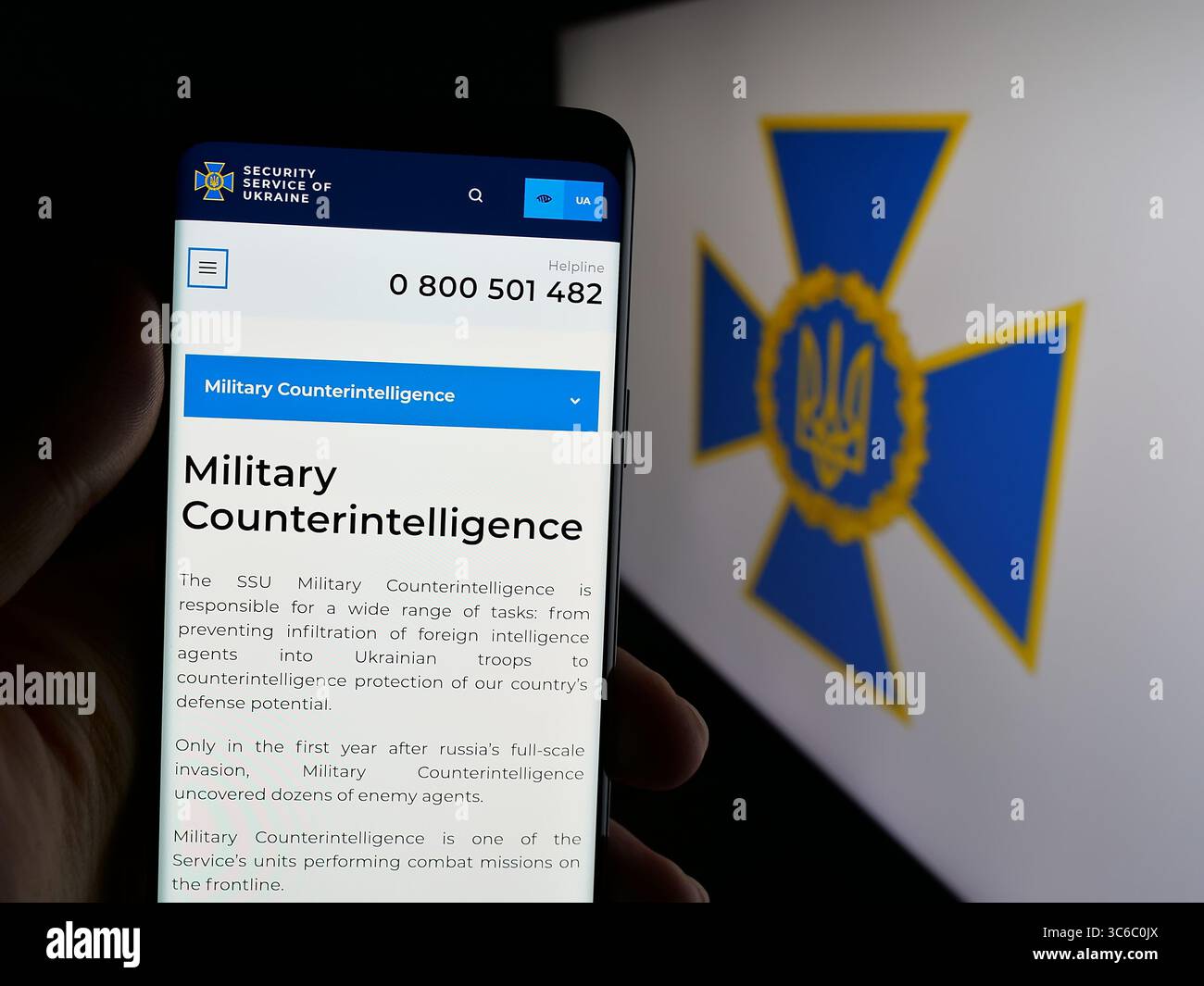 Stoccarda, Germania - 06-18-2025: Persona con smartphone con pagina web del servizio di sicurezza Sluzhba Bezpeky Ukrainy SBU sullo schermo davanti al logo. Foto Stock
