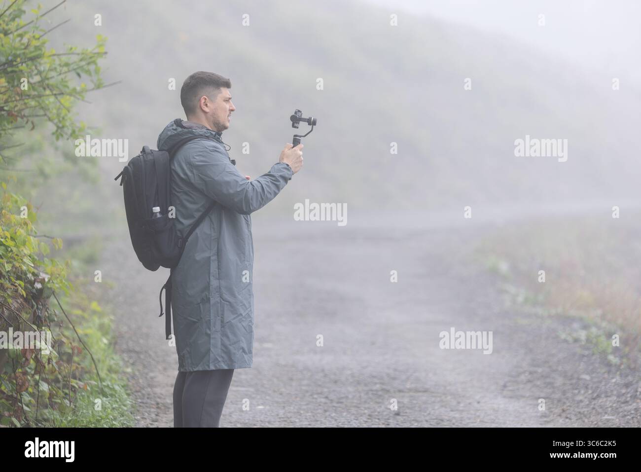 Un uomo registra un video per un blog in una giornata nebbiosa Foto Stock