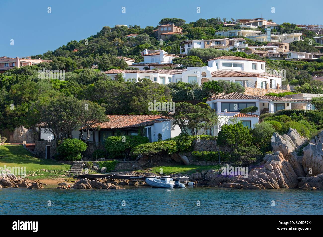 Porto Cervo, Costa Smeralda, Gallura, Sardegna, Italia. Grandi case di lusso aggrappate a verdeggianti colline sopra il porto. Foto Stock