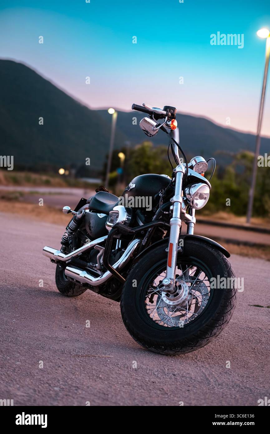 Una Harley-Davidson sfreccia lungo la strada, catturata in movimento e quiete: L'essenza della libertà su due ruote. Foto Stock