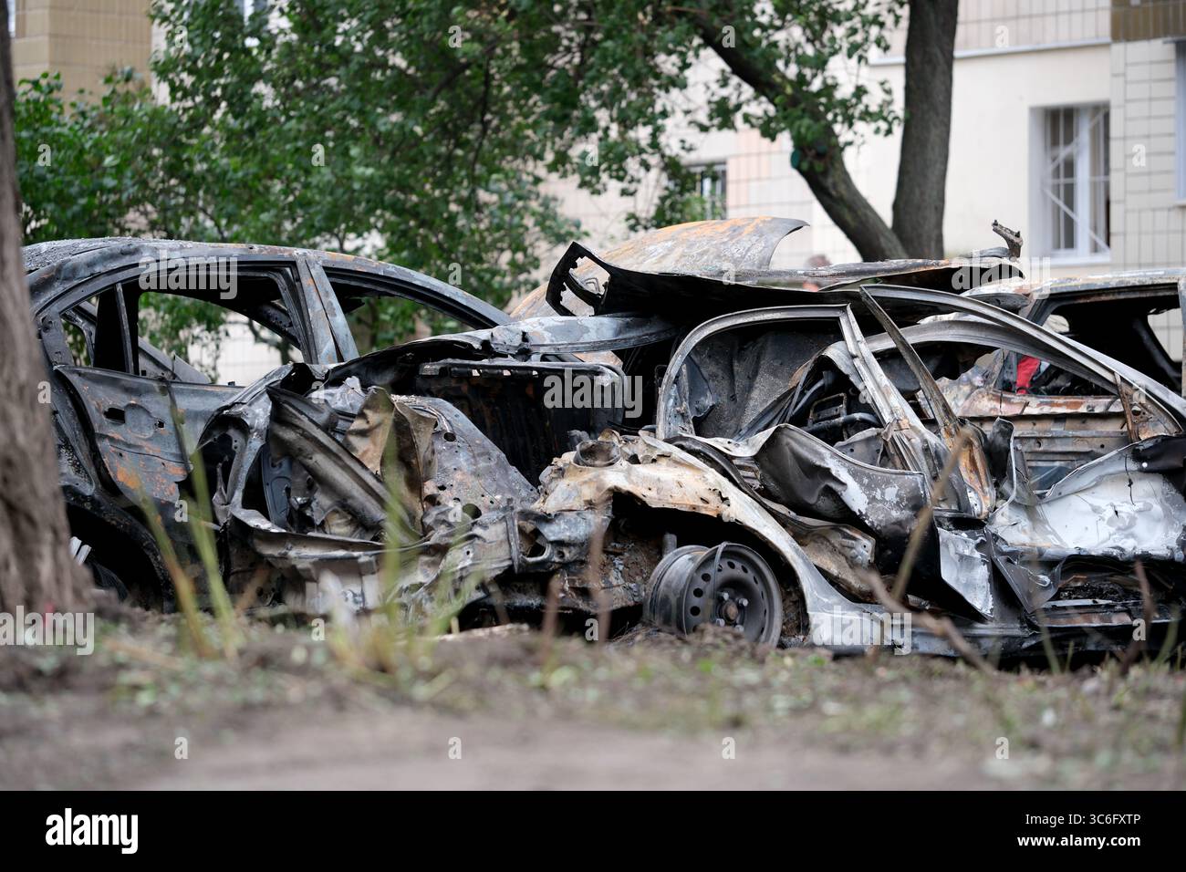 Resti carbonizzati di auto evidenziano l'abbandono di una zona deserta della città. Foto Stock