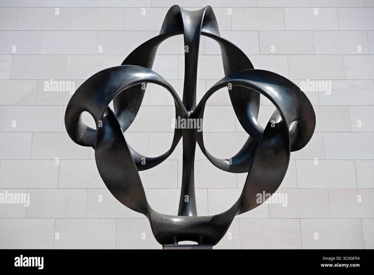 WASHINGTON DC - la scultura Continuum di Charles O. Perry è un'opera d'arte in bronzo alta 4 metri che esplora il concetto matematico della striscia di Möbius, posizionata all'ingresso di Independence Avenue del National Air and Space Museum. Perry ha progettato la scultura di 9.000 libbre con otto pezzi di bronzo separati montati su una base di granito, utilizzando un rivestimento in cera nera per creare un netto contrasto con l'esterno del museo. La scultura è stata commissionata appositamente per l'apertura bicentenaria del museo il 1 luglio 1976, quando il presidente Gerald Ford presiedette le cerimonie che includevano un taglio del nastro Foto Stock