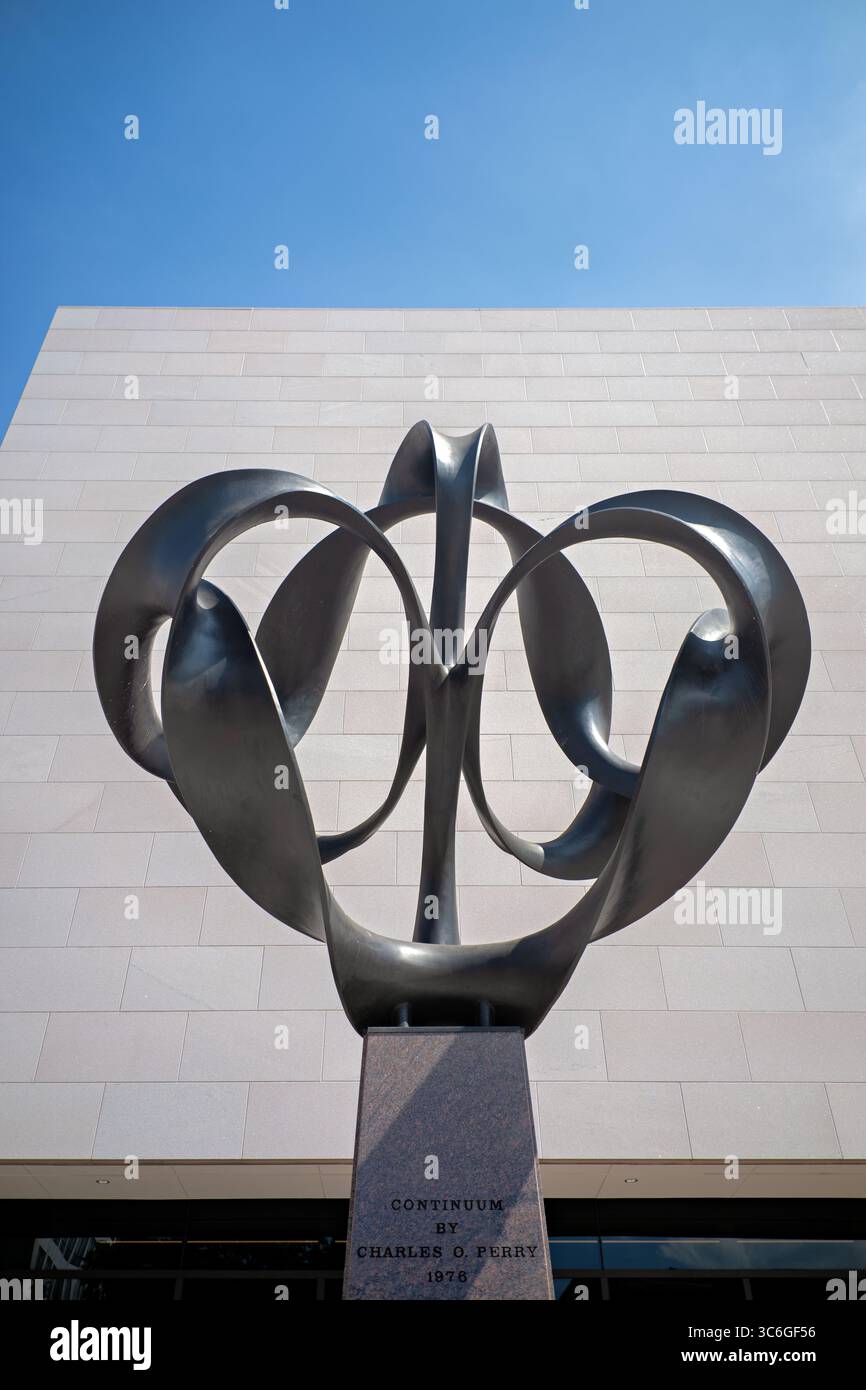 WASHINGTON DC - la scultura Continuum di Charles O. Perry è un'opera d'arte in bronzo alta 4 metri che esplora il concetto matematico della striscia di Möbius, posizionata all'ingresso di Independence Avenue del National Air and Space Museum. Perry ha progettato la scultura di 9.000 libbre con otto pezzi di bronzo separati montati su una base di granito, utilizzando un rivestimento in cera nera per creare un netto contrasto con l'esterno del museo. La scultura è stata commissionata appositamente per l'apertura bicentenaria del museo il 1 luglio 1976, quando il presidente Gerald Ford presiedette le cerimonie che includevano un taglio del nastro Foto Stock