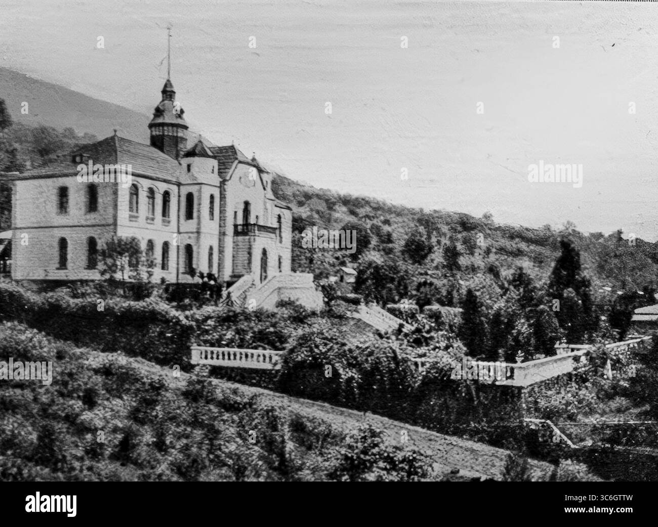 Vista del Palazzo del Governatore tedesco a Buea, capitale del Kamerun tedesco, durante l'offensiva alleata del 1916 in Camerun. Situato sulle pendici del Monte Camerun, l'edificio simboleggiava l'autorità coloniale prima della cattura della città da parte delle forze francesi e britanniche. La linea ferroviaria visibile in primo piano evidenzia la sua importanza logistica nel trasporto di truppe e rifornimenti nell'entroterra durante la campagna dell'Africa occidentale. Foto Stock