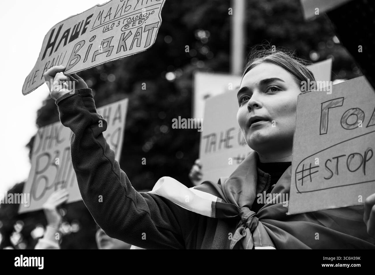 Kiev, Ucraina - 31 luglio 2025: Giovane donna Ucraina che solleva un segnale durante una protesta per l'indipendenza, circondata da attivisti che chiedono la responsabilità di NABU e SAPO. Contex ( il 22 luglio, la Verkhovna Rada votò per una legge che scatenò proteste in Ucraina. L'iniziativa prevedeva che i due principali organismi anticorruzione (NAB e SAPO) sarebbero stati trasferiti sotto il controllo del procuratore generale. Dopo numerose proteste e pressioni pubbliche, la Verkhovna Rada votò per garantire l'indipendenza di questi organismi ) Foto Stock