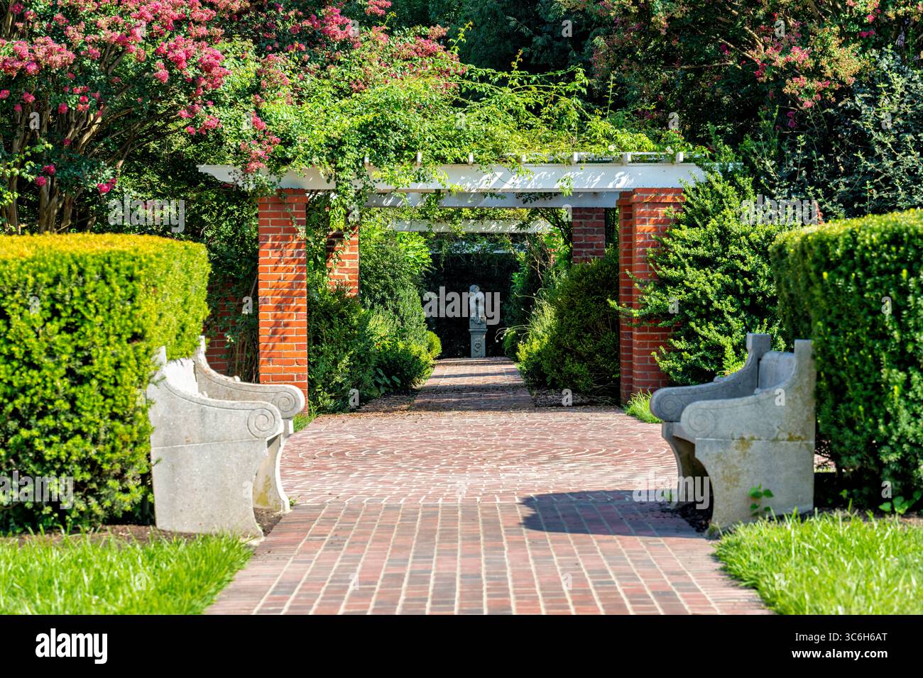 ALEXANDRIA, Virginia - Un sentiero dritto pavimentato in mattoni con panchine su ogni lato conduce attraverso i giardini della George Washington's River Farm, la storica proprietà di 25 ettari che serviva come la più grande delle cinque fattorie di Washington all'interno del suo complesso immobiliare di Mount Vernon. Washington acquisì questo tratto di 1.800 acri nel 1760 per l'agricoltura sperimentale, implementando rivoluzionari sistemi di rotazione delle colture della durata di sette anni e innovative tecniche di fertilizzazione utilizzando il fango del fiume Potomac. L'American Horticultural Society ha gestito la proprietà come quartier generale nazionale dal 1973, mantenendo entrambi il 1757 Foto Stock ALEXANDRIA, Virginia - Un sentiero dritto pavimentato in mattoni con panchine su ogni lato conduce attraverso i giardini della George Washington's River Farm, la storica proprietà di 25 ettari che serviva come la più grande delle cinque fattorie di Washington all'interno del suo complesso immobiliare di Mount Vernon. Washington acquisì questo tratto di 1.800 acri nel 1760 per l'agricoltura sperimentale, implementando rivoluzionari sistemi di rotazione delle colture della durata di sette anni e innovative tecniche di fertilizzazione utilizzando il fango del fiume Potomac. L'American Horticultural Society ha gestito la proprietà come quartier generale nazionale dal 1973, mantenendo entrambi il 1757 Foto Stock