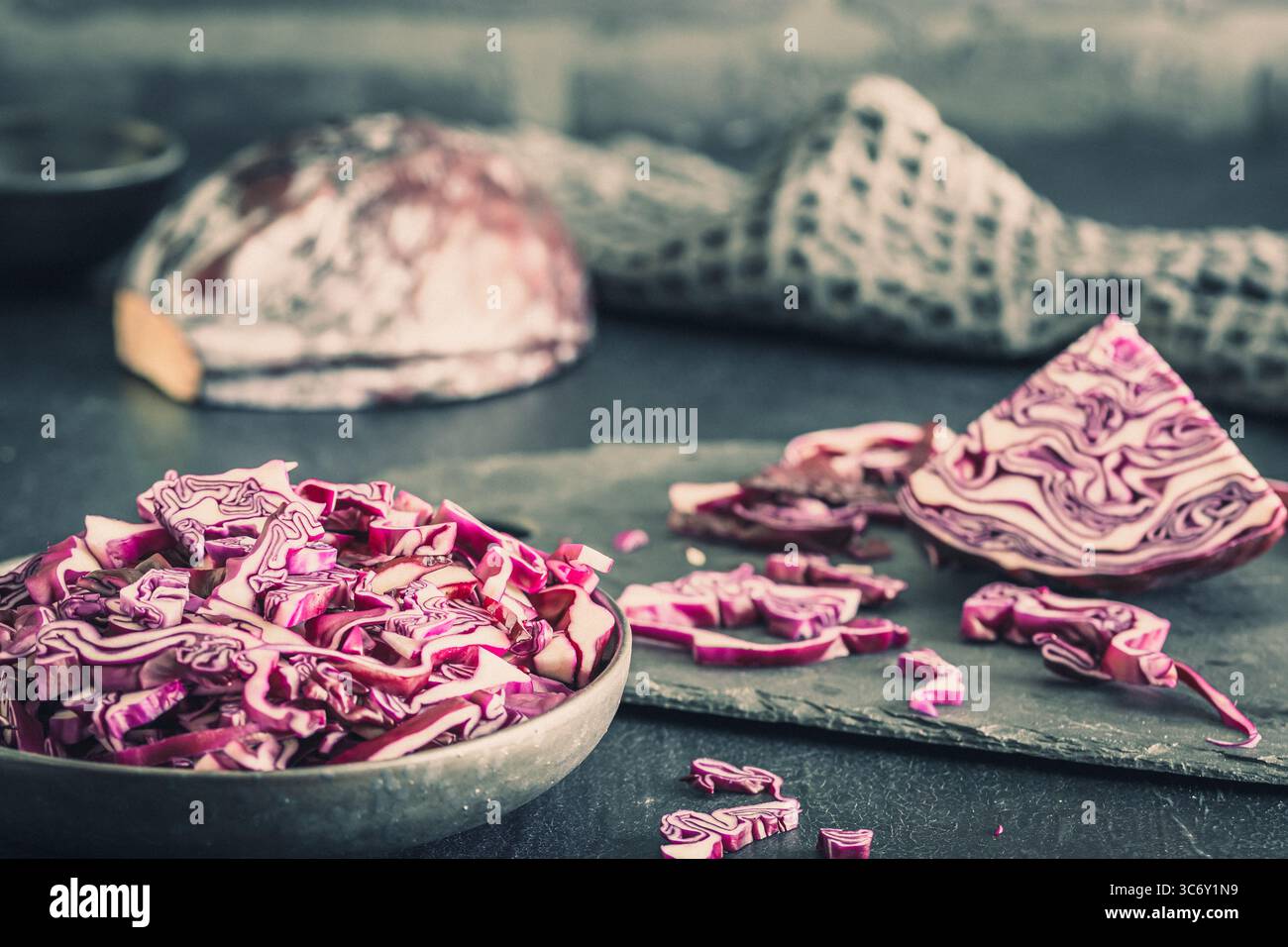 Cavolo rosso fresco, tagliato a pezzi e a strisce, su tavola grigia. Foto Stock