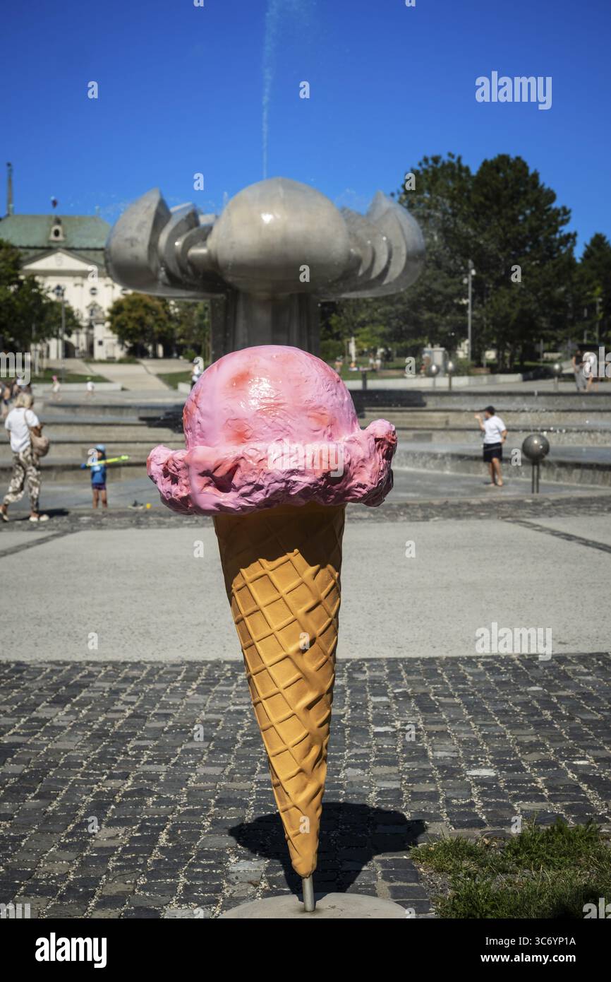 Gelati giganti si trovano in Piazza della libertà con una fontana a forma di fiore di calce a Bratislava, Slovacchia Foto Stock