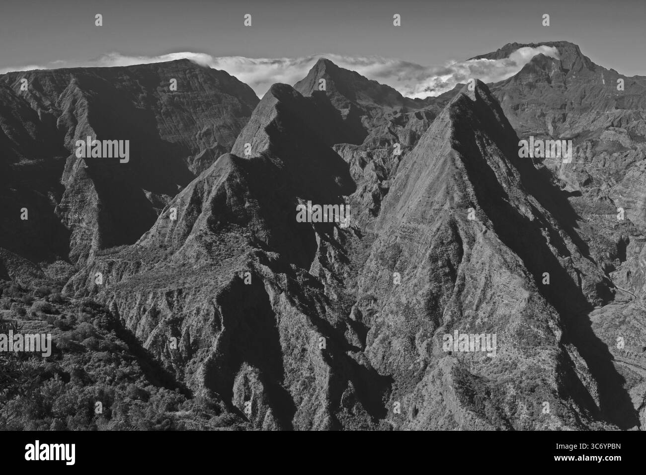 Aspre vette montane parzialmente avvolte da nuvole in bianco e nero. La Reunion, Francia Foto Stock