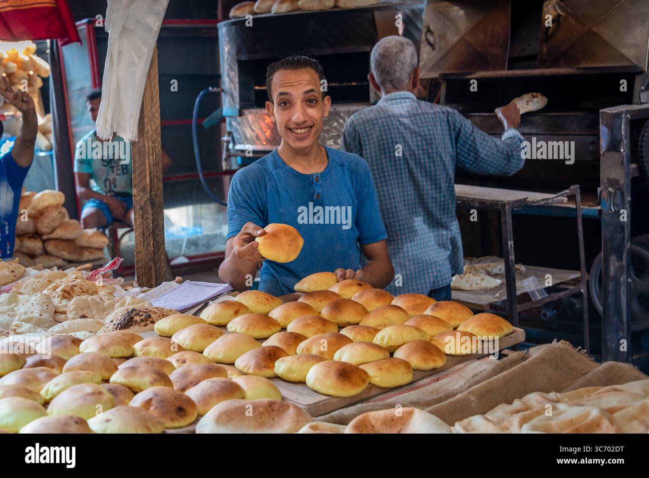ALESSANDRIA d'EGITTO - 3 AGOSTO 2021: Baker vende pane in una panetteria di Alessandria, Egitto Foto Stock
