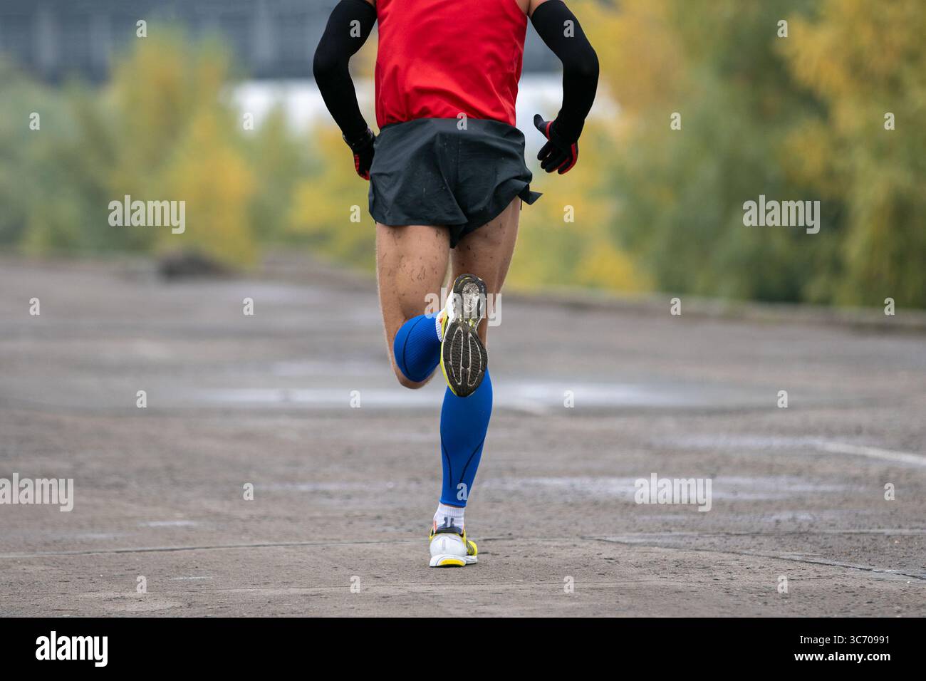 maratona di corsa uomo retrovisiva a maniche lunghe e calzini a compressione Foto Stock