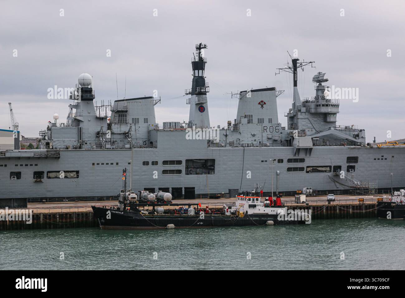 HM Naval base Portsmouth, Hampshire, Regno Unito: La portaerei leggera della Royal Navy HMS ILLUSTRIOUS (R06) | Serco Denholm bunkering tanker SD TEESDALE Foto Stock
