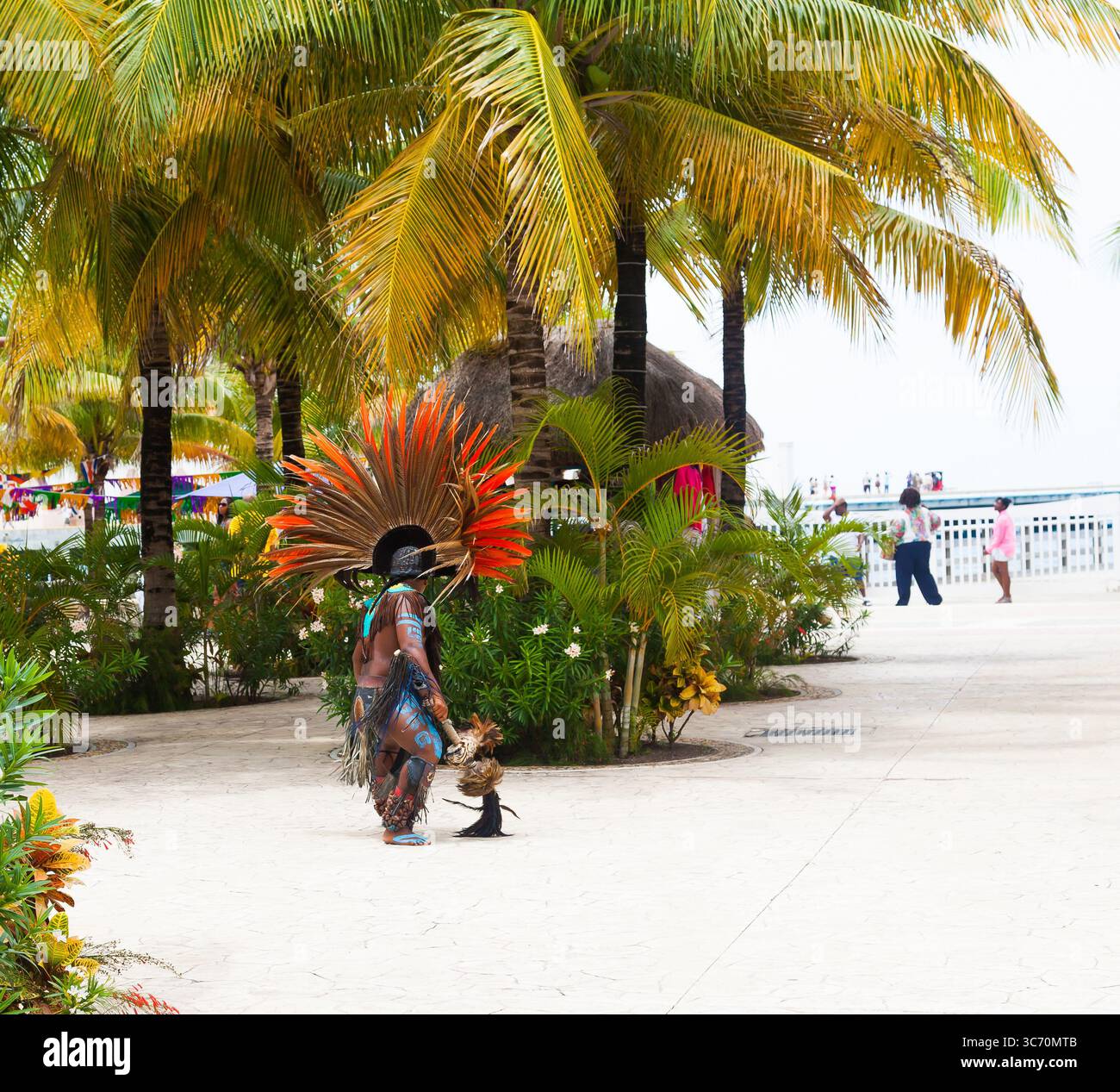 Aborigeno colorato in costume etnico tra le palme della città. Foto Stock