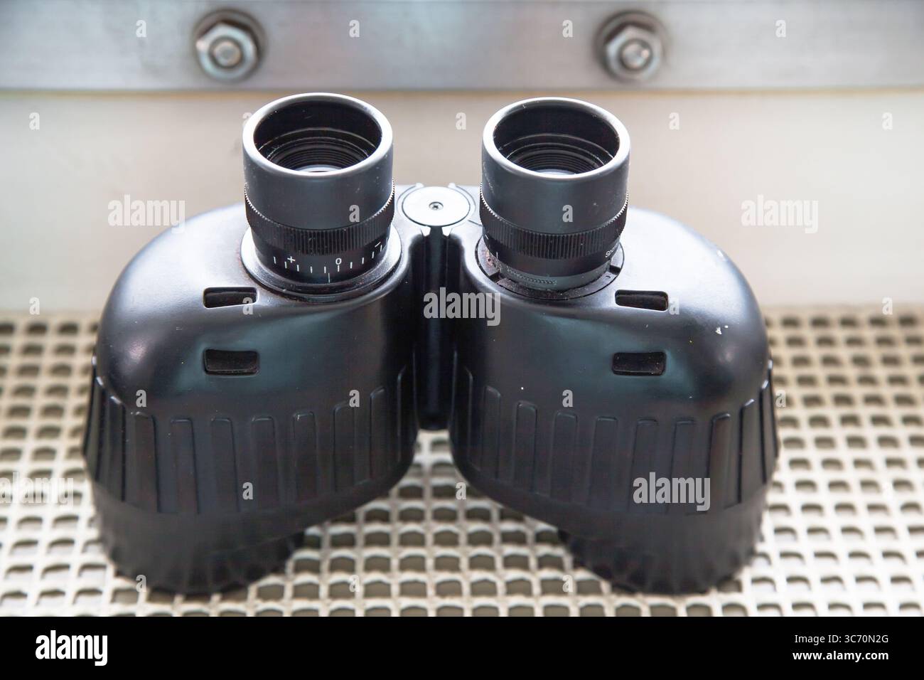Binocolo su un ponte navale vicino all'oblò. Foto Stock