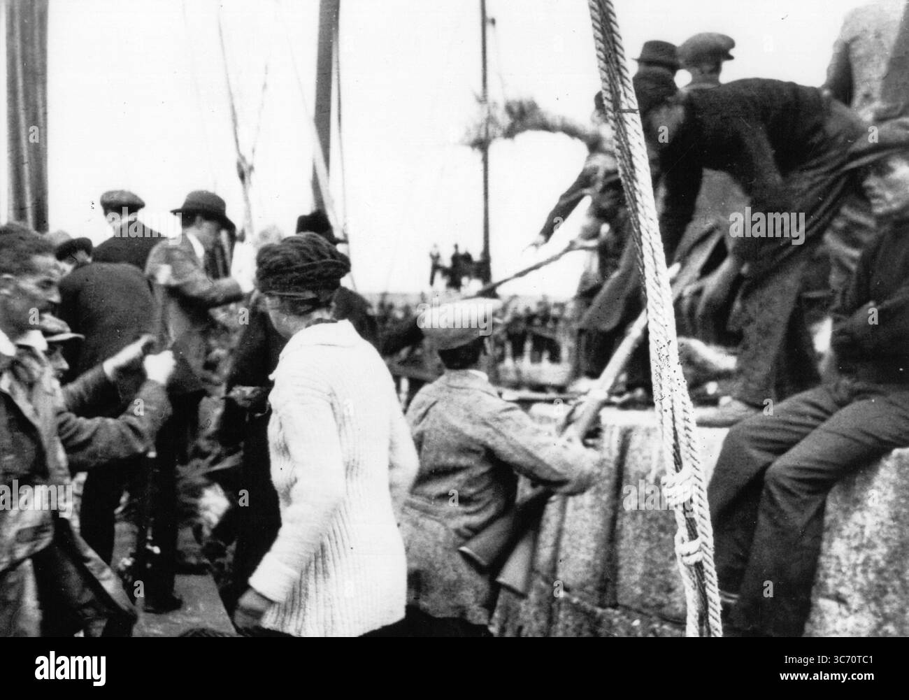 Robert Erskine Childers come armi vengono caricate dall' Asgard di Howth . 1914 a bordo di Asgard al molo di Howth, Molly Childers, Robert Erskine Childers e Irish Volunteers che maneggiavano pistole Asgard fu l'ultimo e più famoso yacht di Childers: Nel giugno 1914 lo usò per contrabbandare un carico di 900 anziani ma efficienti fucili Mauser Model 1871 e 29.000 cartucce di polvere nera al movimento dei volontari irlandesi nel villaggio di pescatori di Howth, nella contea di Dublino (in seguito conosciuto come il 'Howth-running di pistola Howth'). Fu acquistata dal governo irlandese come nave da addestramento nel 1961, immagazzinata sulla terraferma nel ya Foto Stock