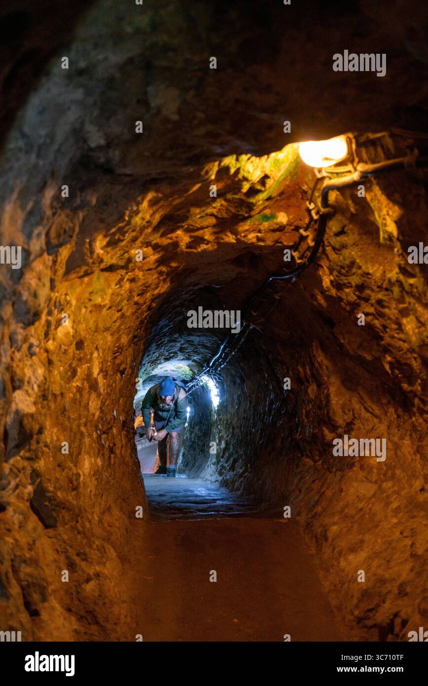 Uomo che esplora gli antichi tunnel della città sotterranea di Derinkuyu Foto Stock