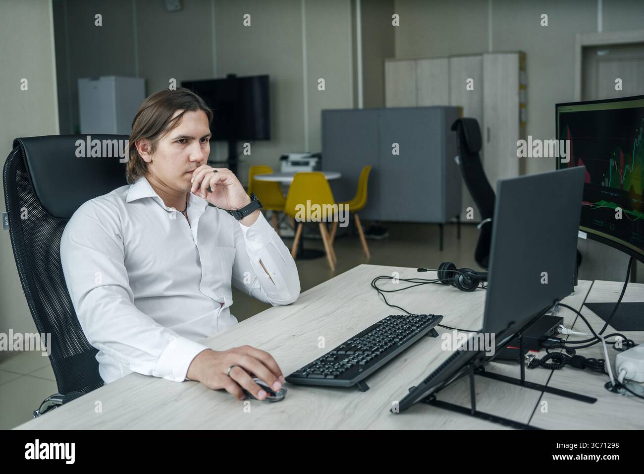 Uomo che lavora al suo computer in un ufficio moderno. Foto Stock