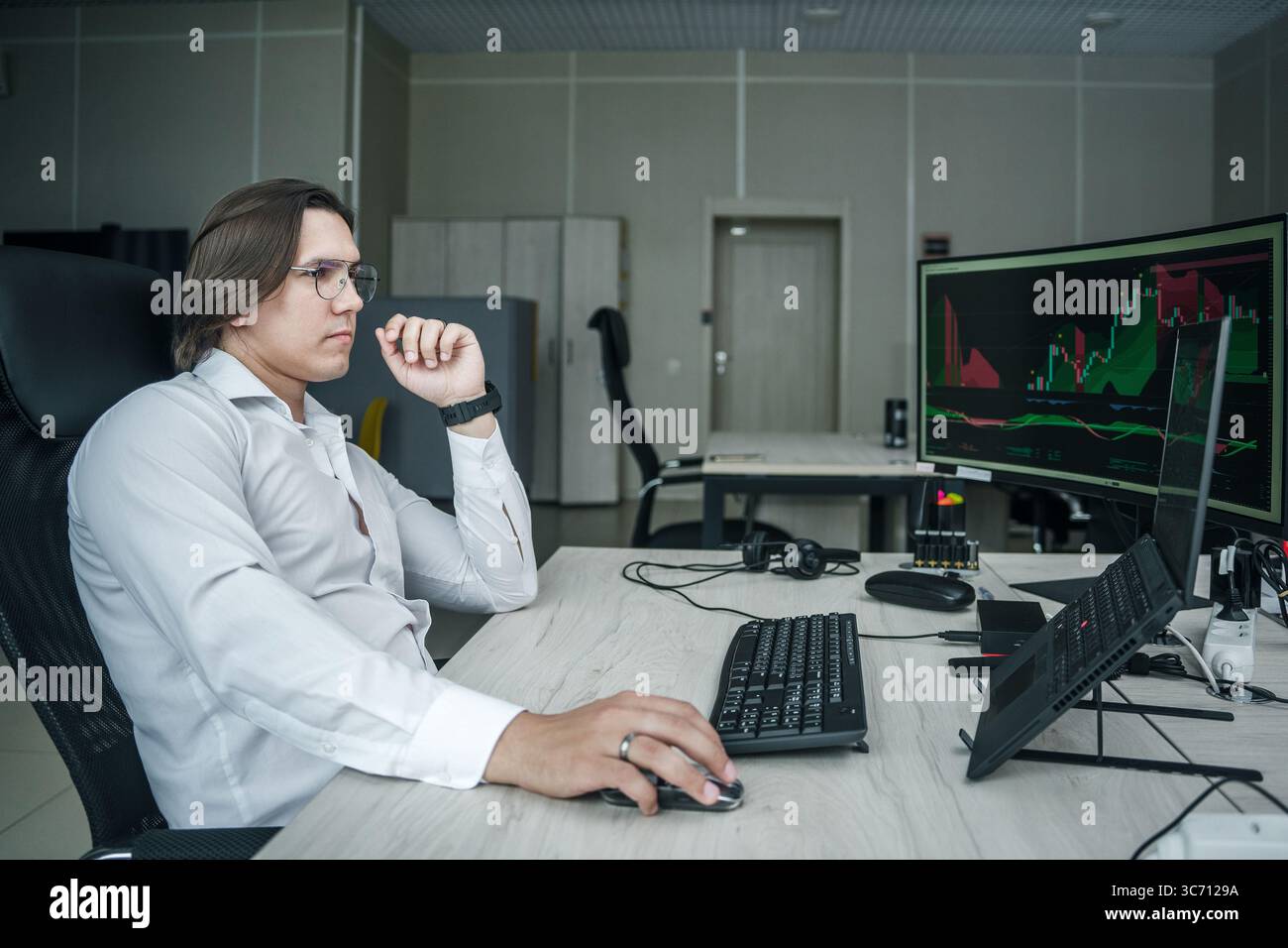 Uomo che lavora al suo computer in un ufficio moderno. Foto Stock