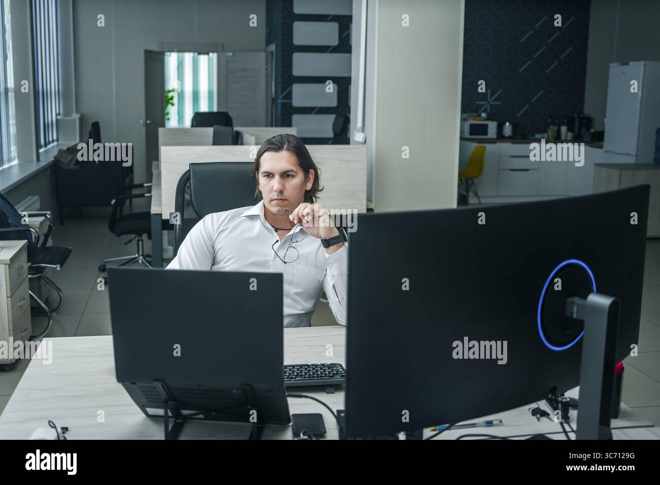 Uomo che lavora al suo computer in un ufficio moderno. Foto Stock