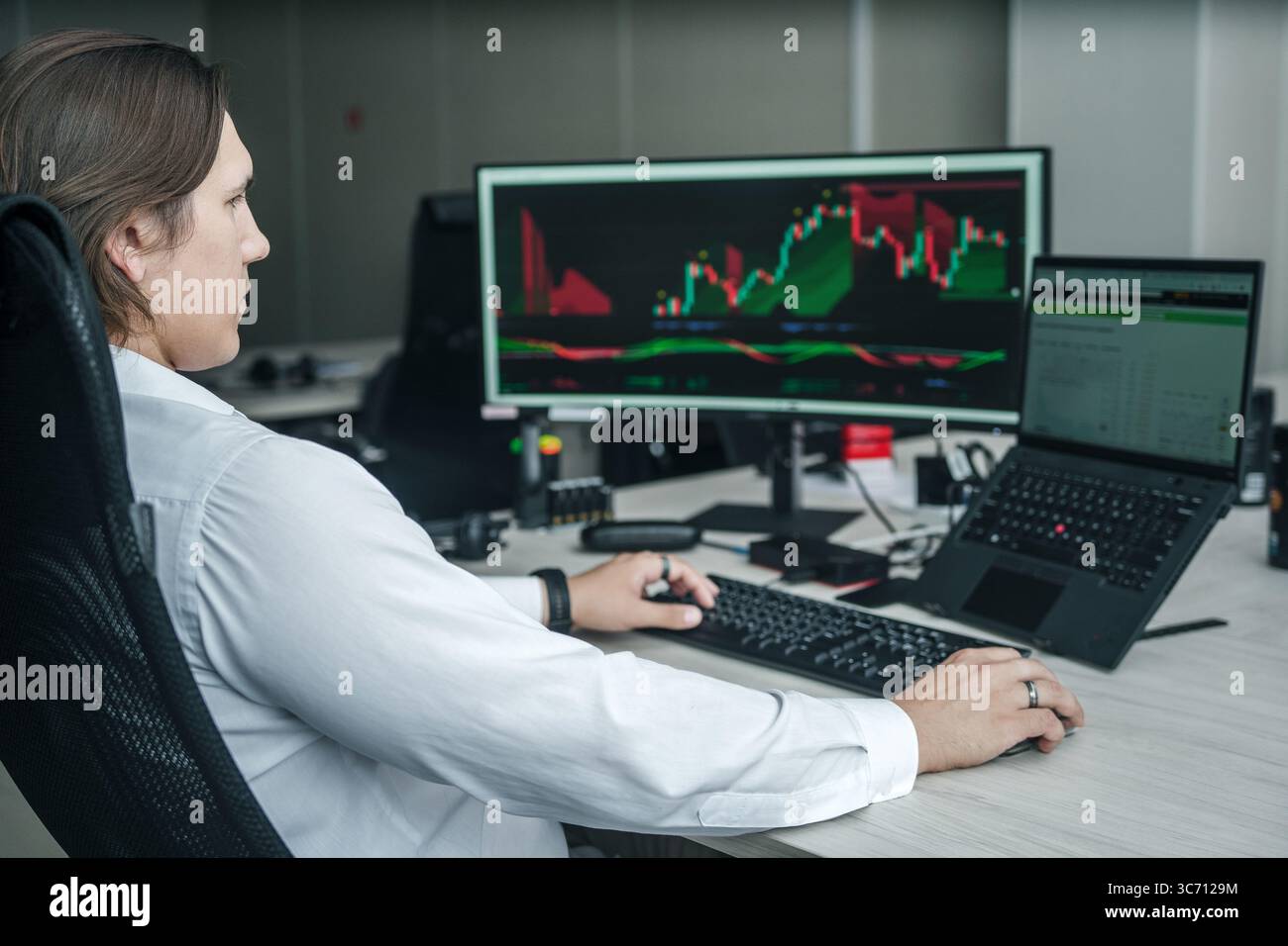 Uomo che lavora al suo computer in un ufficio moderno. Foto Stock