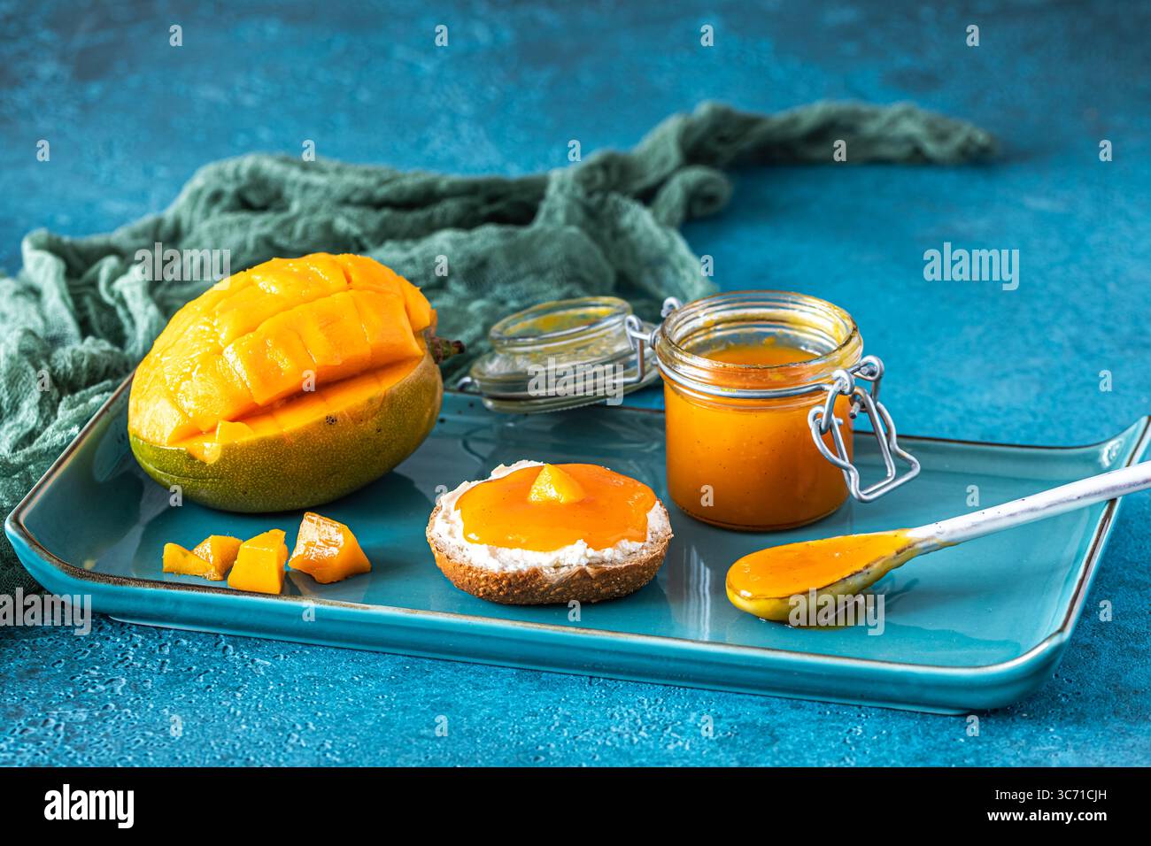 Chuntney di mango fatto in casa e ingredienti su sfondo blu Foto Stock
