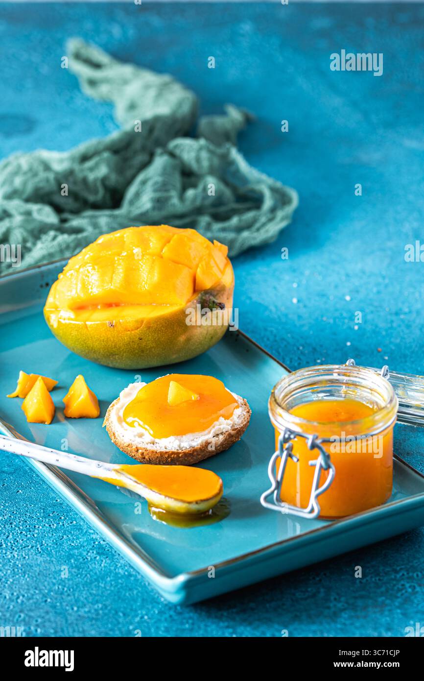 Chuntney di mango fatti in casa e ingredienti su sfondo blu, verticale Foto Stock