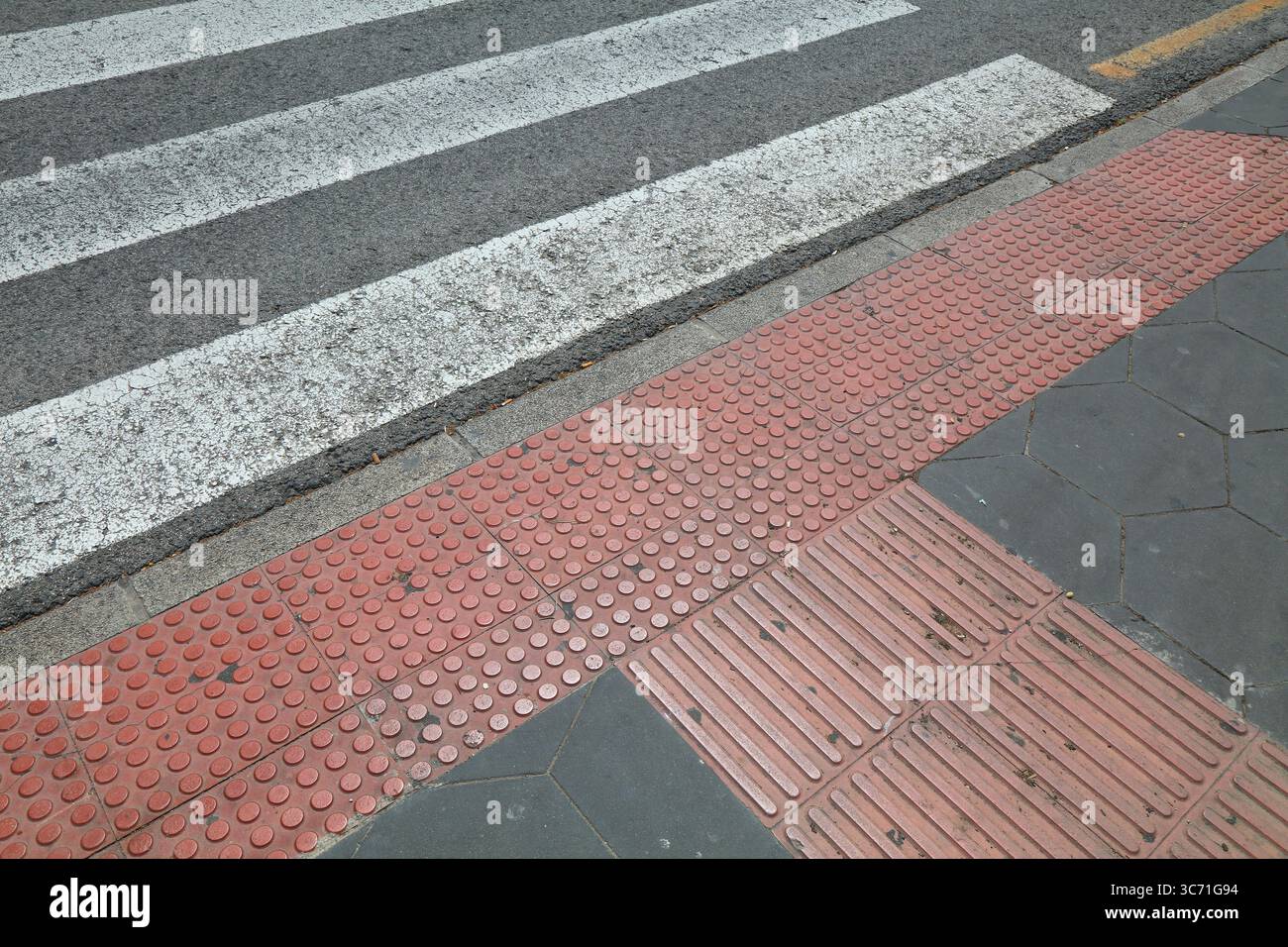 Pavimentazione tattile (blocchi tenji) presso l'attraversamento pedonale a Benidorm, Spagna. Foto Stock